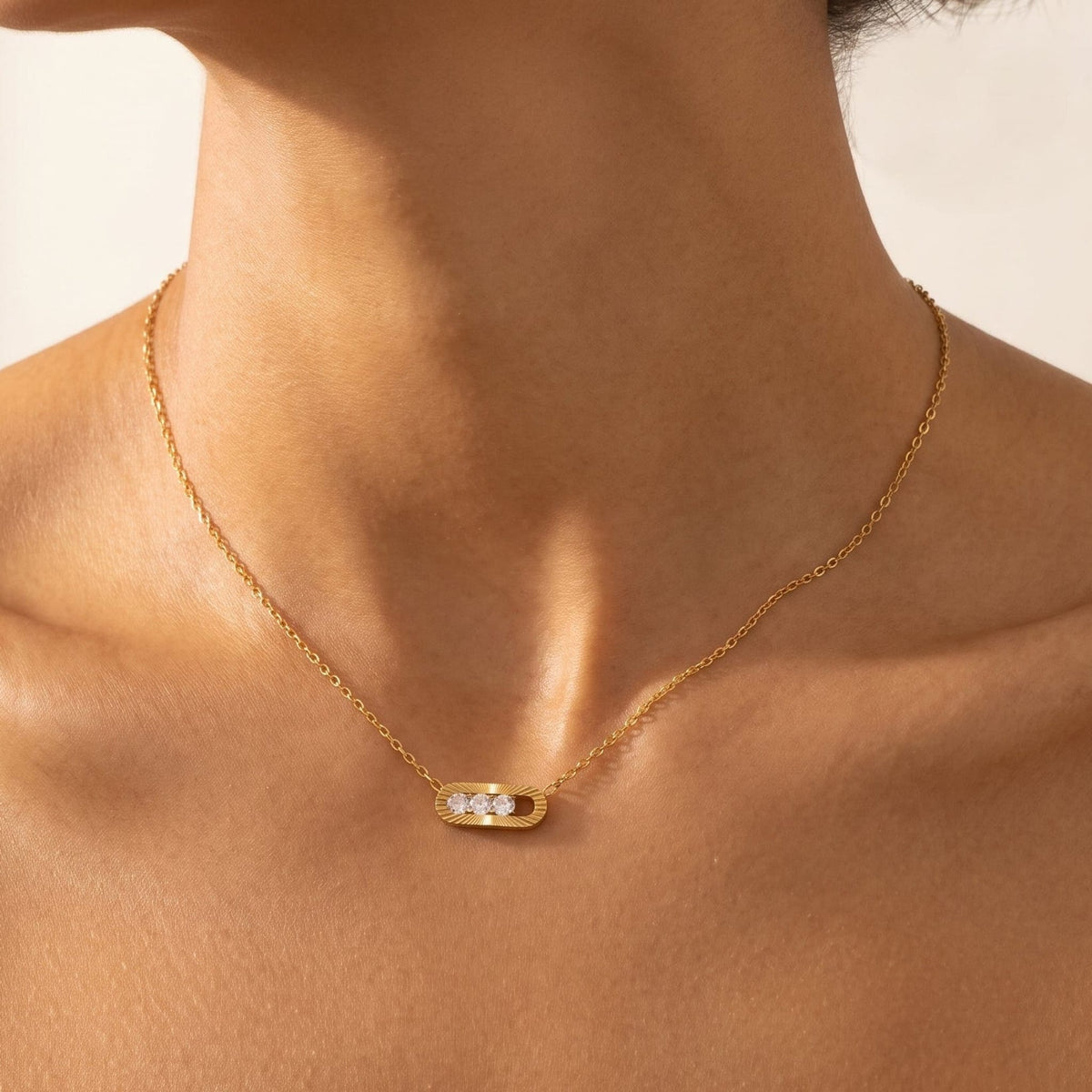 Woman wearing the Margaux sliding crystal gold necklace at the collarbone