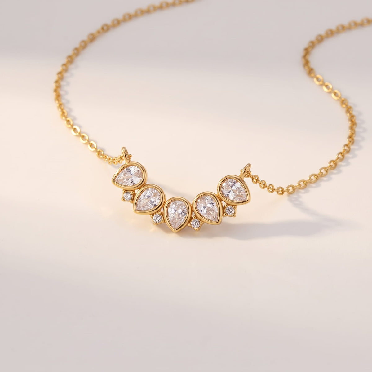 Mélisande crystal crescent gold necklace on a off-white surface under warm light