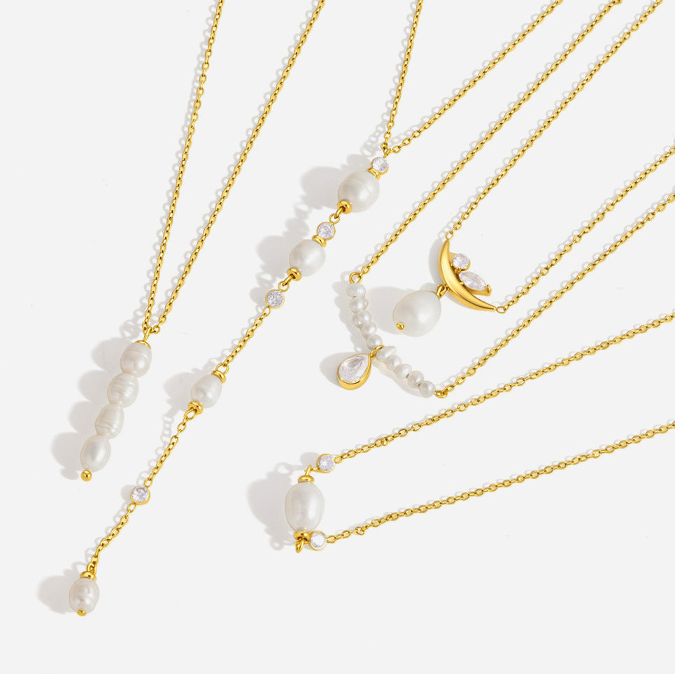 Simone stacked pearl pendant at the left of a fan of gold pearl necklaces on white