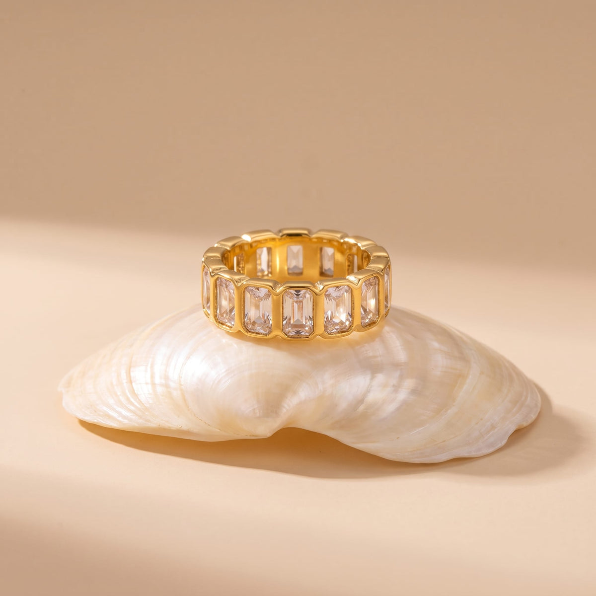 Sophie baguette eternity gold ring on a white seashell