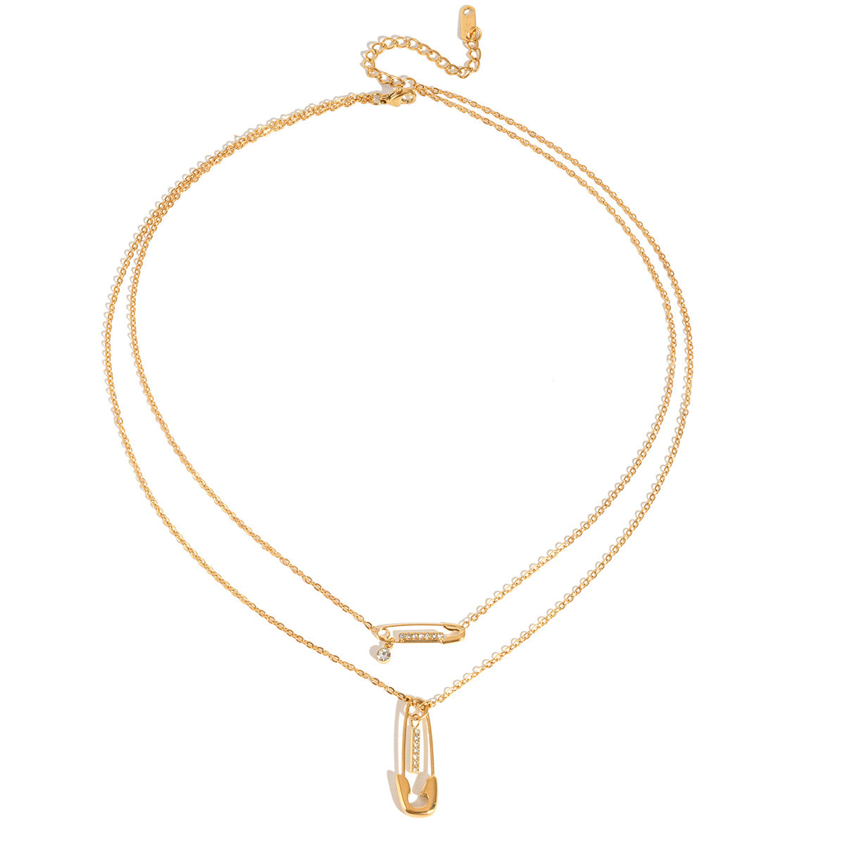 Stella safety pin necklace laid flat on white, both chains joined at one clasp and extender